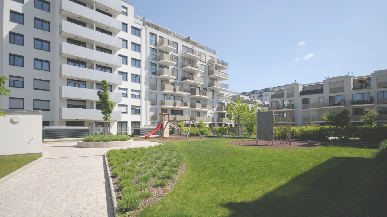 Wohnanlage mit Spielplatz und Grünfläche im Innenhof.
